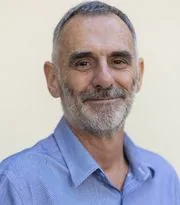 Gary Jolliffe in a blue shirt against a pale wall