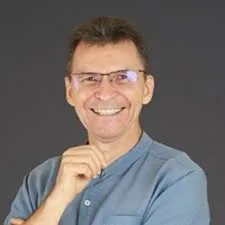 Michel Thibeault smiling with one hand at his chin